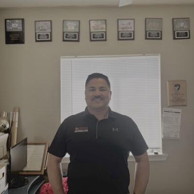Mario Espindola, founder of Econo Roofing, with his framed manufacturer certifications in Delhi