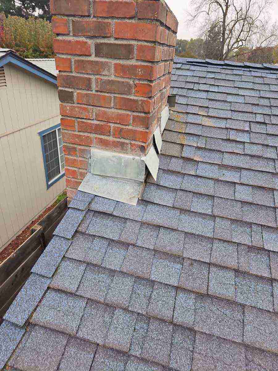 Failed brick chimney flashings on the Atwater home before roof replacement
