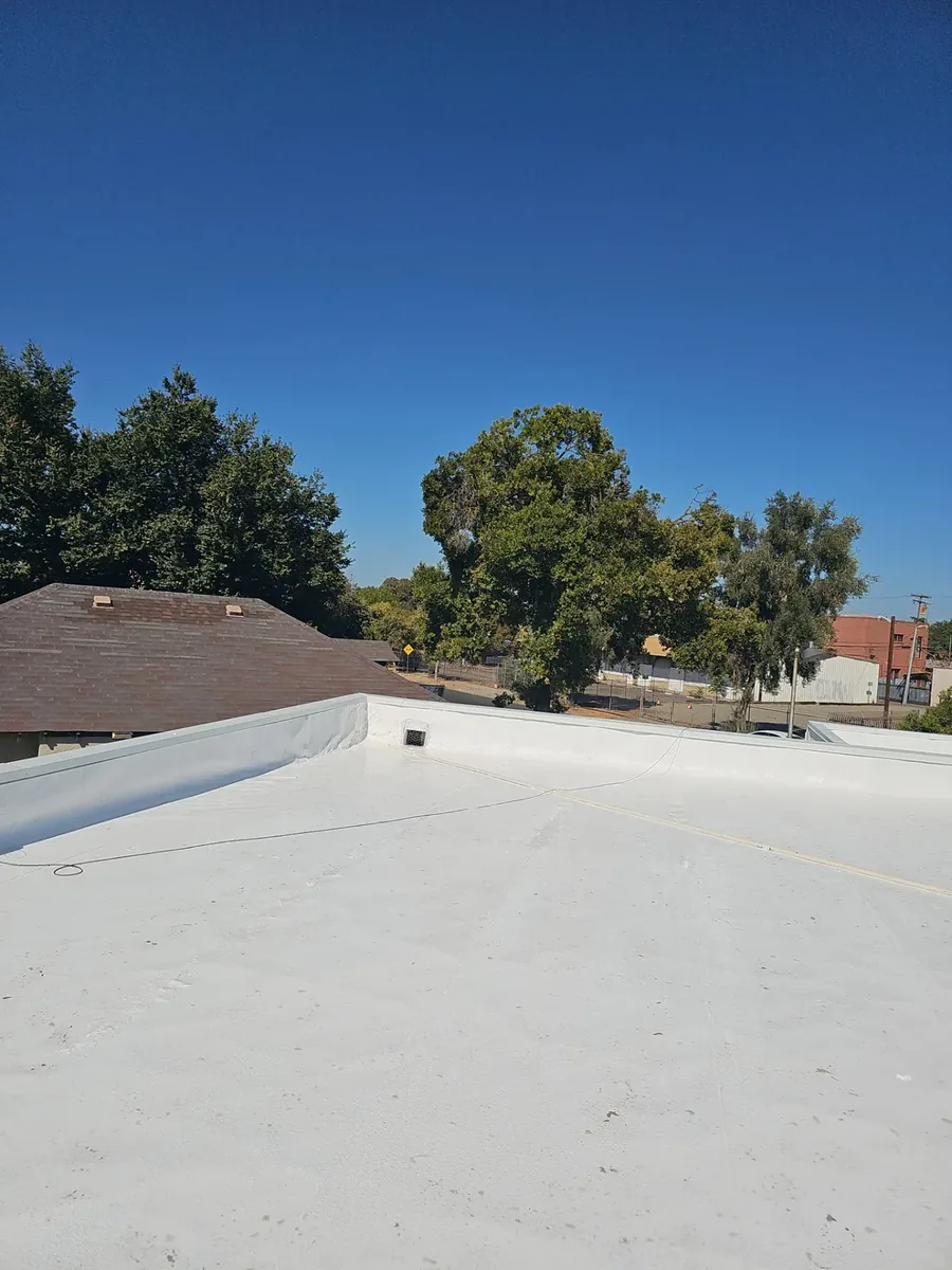 Uniform white reflective coating across the completed Beto's Bakery flat roof in Modesto