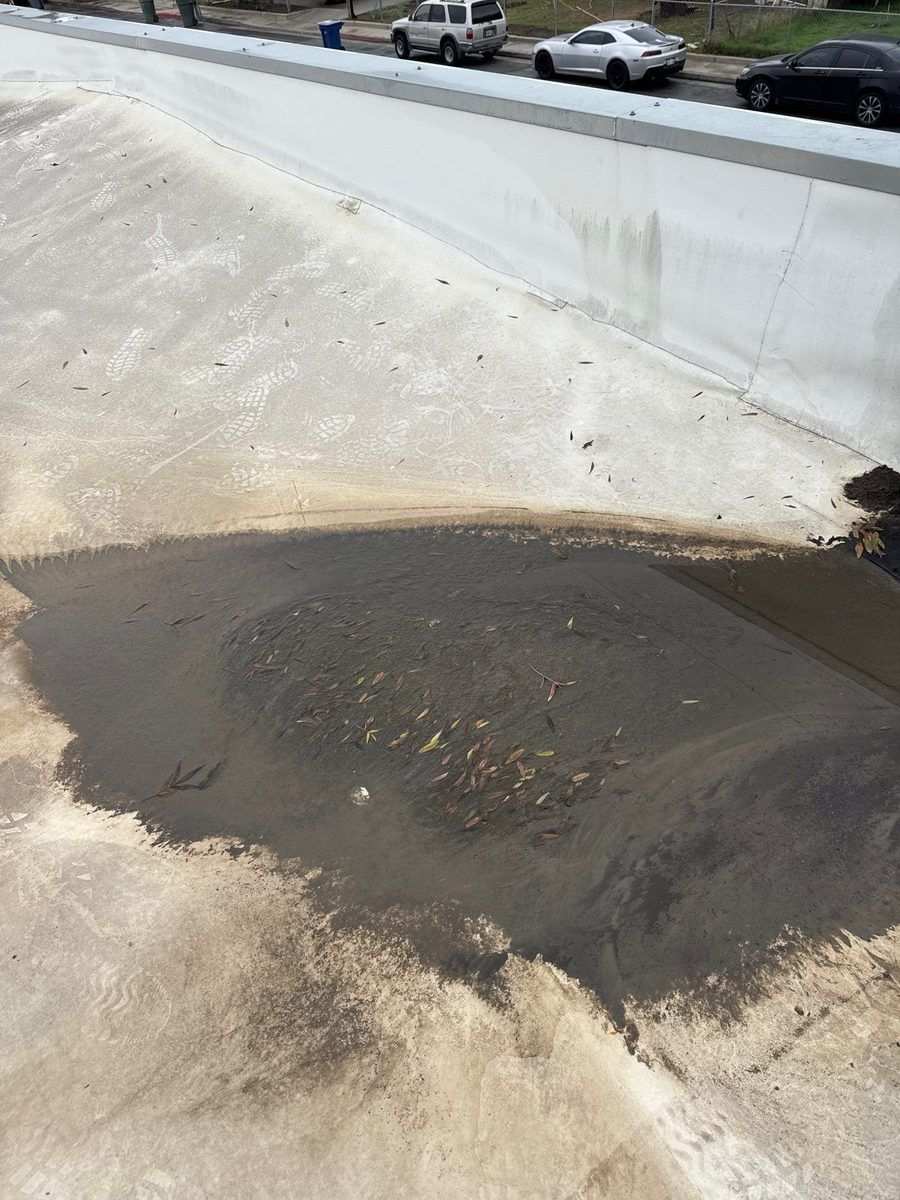 Failed rooftop drain with exposed reinforcement on a Modesto flat roof before repair