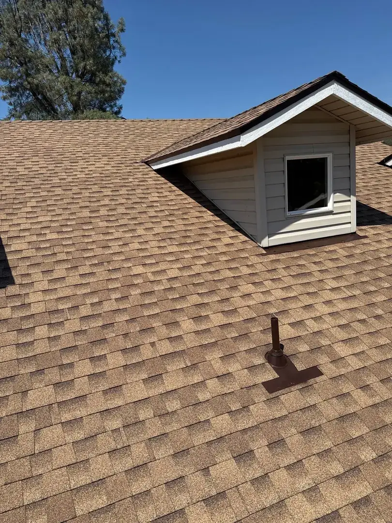 Close-up of new architectural shingles with a white-sided dormer and new vent flashing on the Jamestown roof