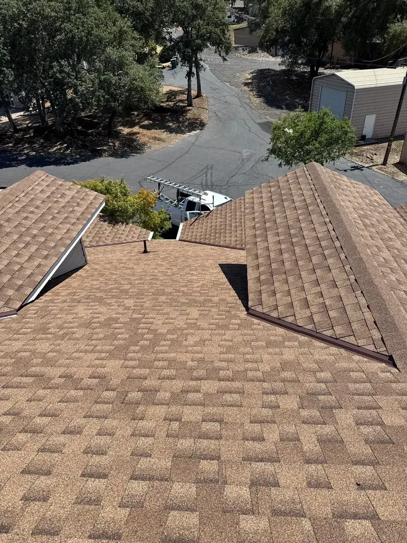 Overhead view of the completed multi-hip roof with the crew truck in the driveway at the Jamestown home