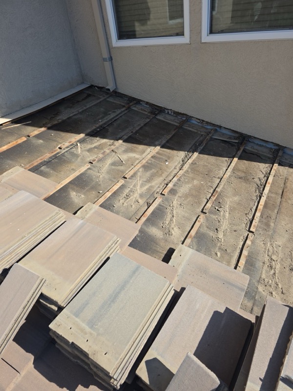 Tiles removed exposing old underlayment near wall