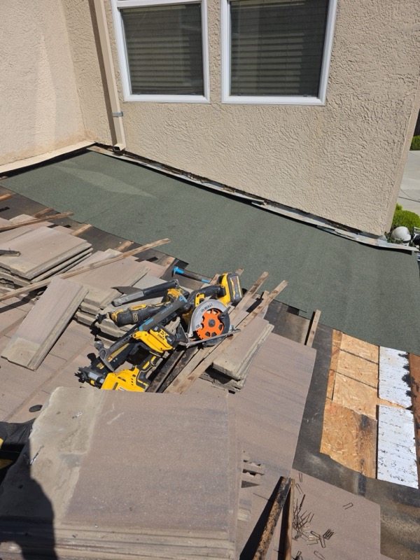 New felt underlayment installed with tools staged