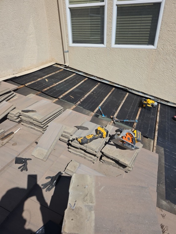 Battens installed near wall, tiles stacked for reset