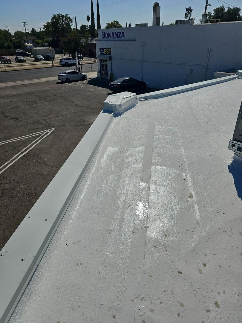 White coated commercial roof with new metal edge trim, downtown Modesto